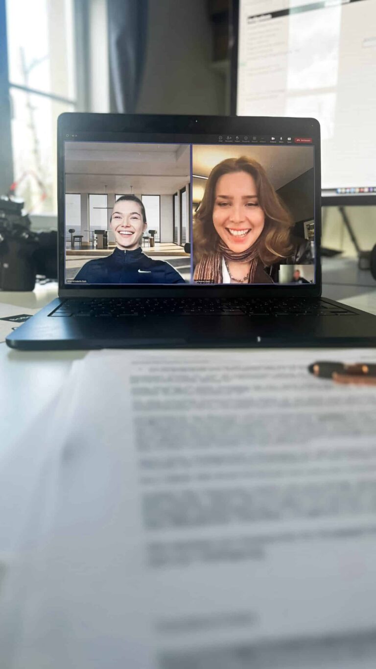 Videocall auf dem Laptop neben Unterlagen