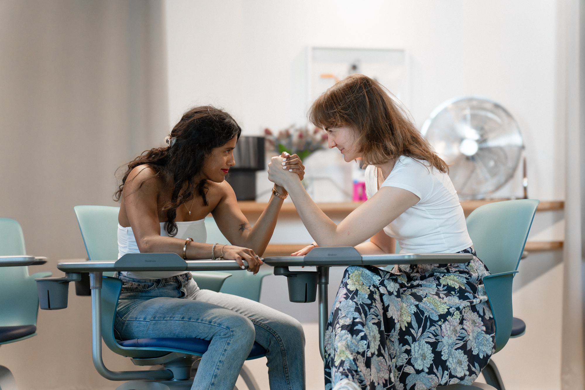 Leena Ranjan und Caroline Vocke beim Armdrücken im Vaternam-Büro